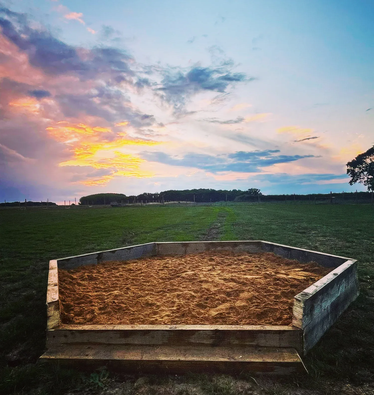 The sandpit and open field at sunset at Curbridge Dog Park
